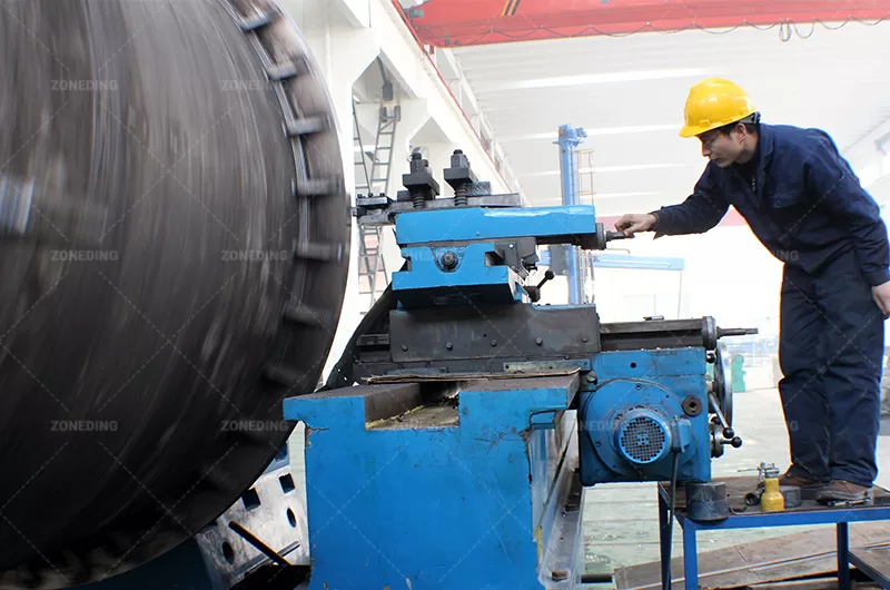 ZONEDING Engineer inspecting the internal structure and materials of a rotary dryer drum